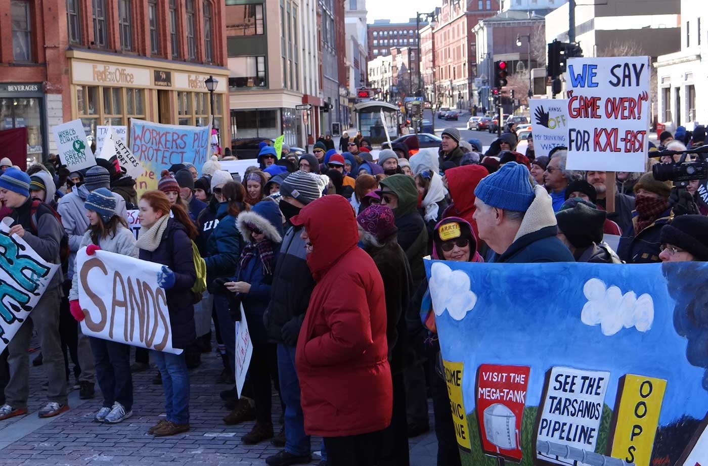 People with signs outside in Monument Square