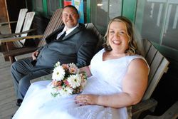 Beth and her new husband, Chris, on the Lodge porch at Camp Mechuwana in Winthrop, sitting in chairs made years ago by Beth's late stepfather, Rev. Walter G. Hartley.