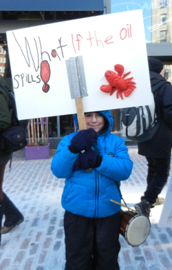 Asking a very important question at the tar sands rally and march on Saturday, January 26, 2013 in Portland, Maine. Photo by Judy Berk.