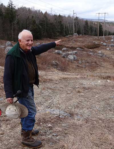 older man pointing across clearing at path of pipeline