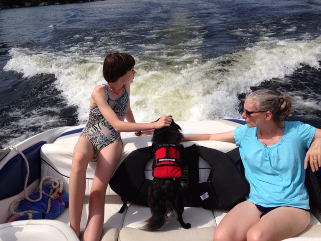 Deanna, Emma, and dog Bailey boating with the Jacksons on Highland Lake, Windham