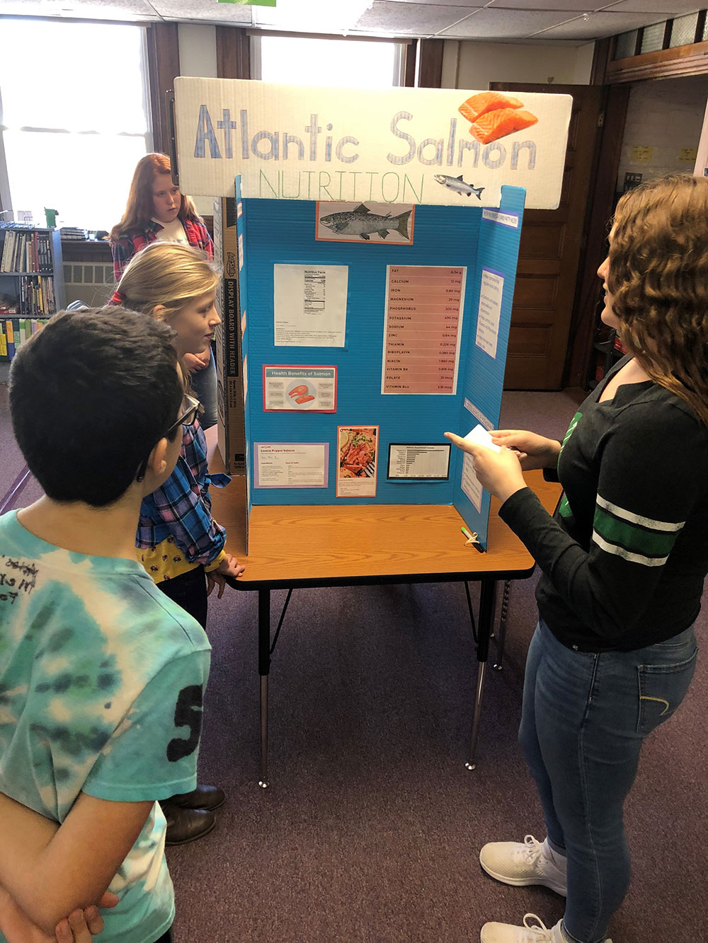 student with salmon poster