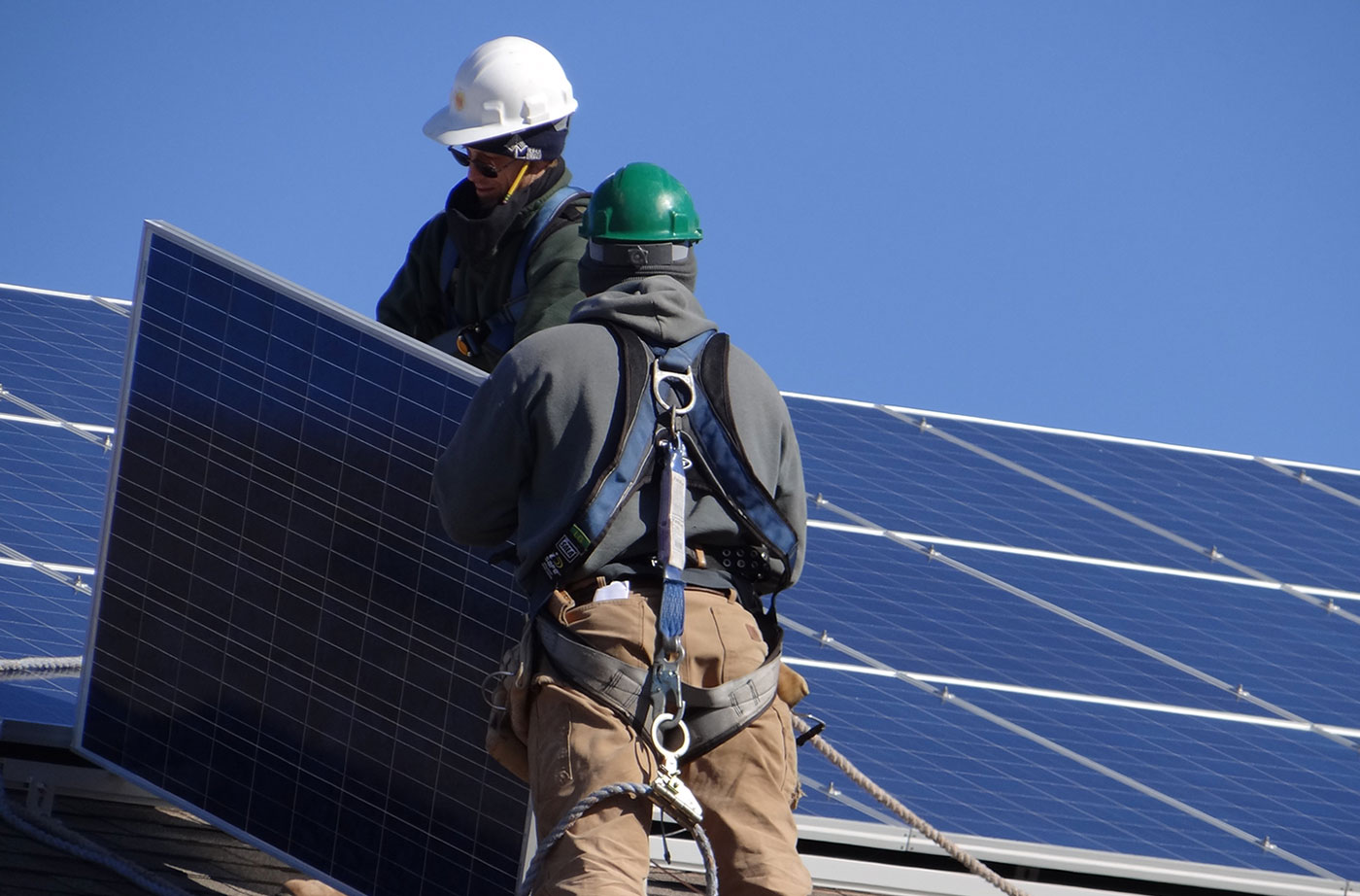 solar workers install panels on roof in Maine