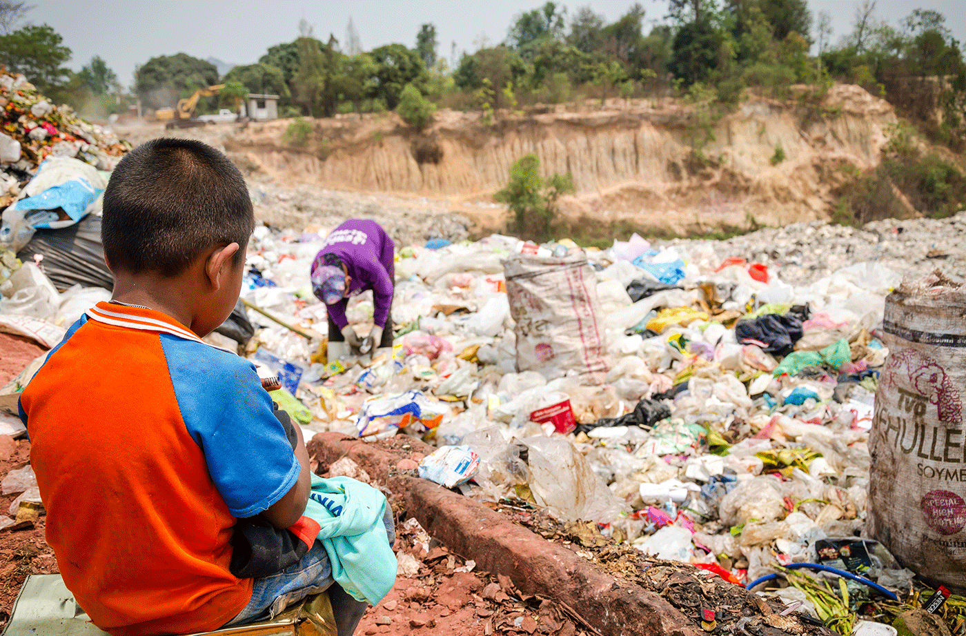 young boy near piles of plastic waste