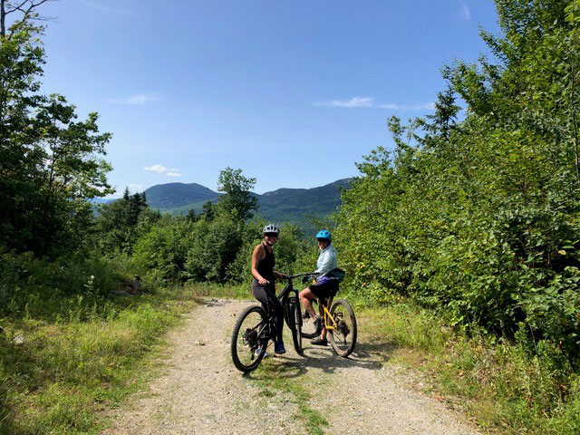 two smiling mountain bikers on trail