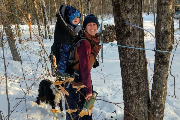 mother and daughter check sap tubing on tree