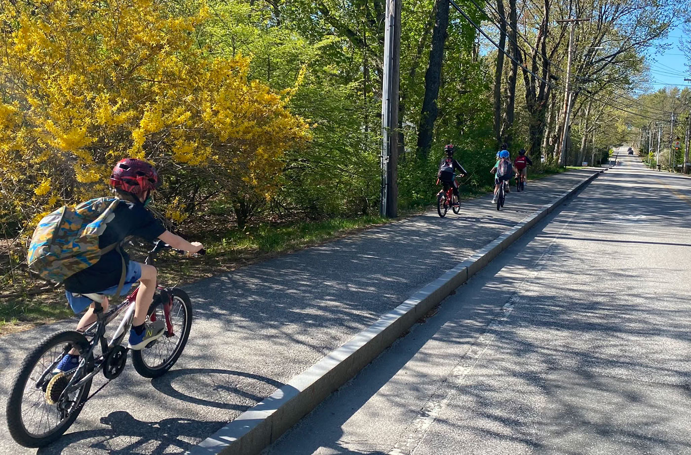 kids riding bikes along road