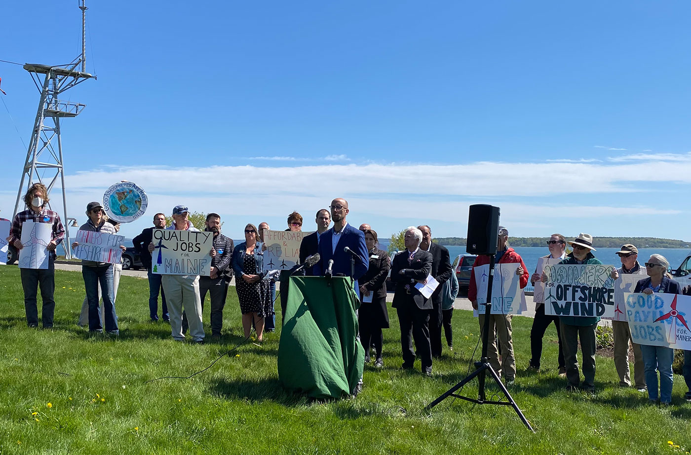 People with signs at offshore wind news conference