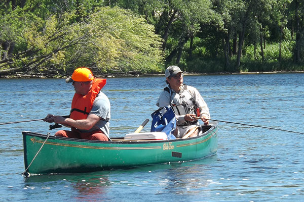 two men fishing from canoe