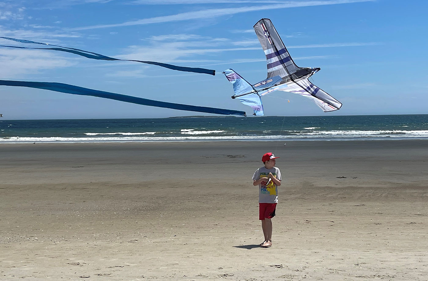boy flying kite on beach