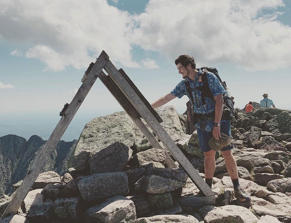 Ethan touching Katahdin sign on summit