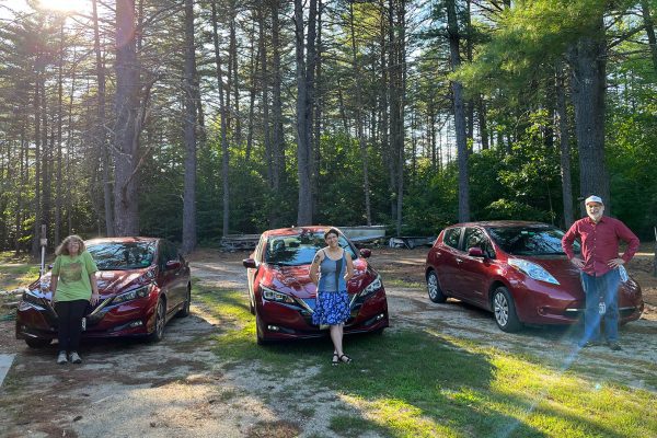 Three people with their electric vehicles