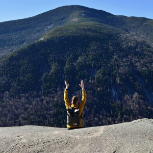 woman sitting with hands in air on Table Rock