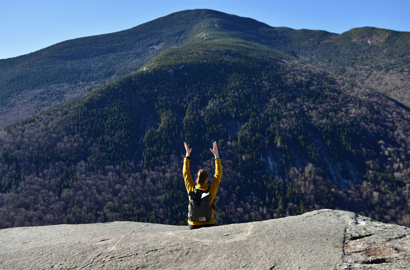 woman sitting with hands in air on Table Rock