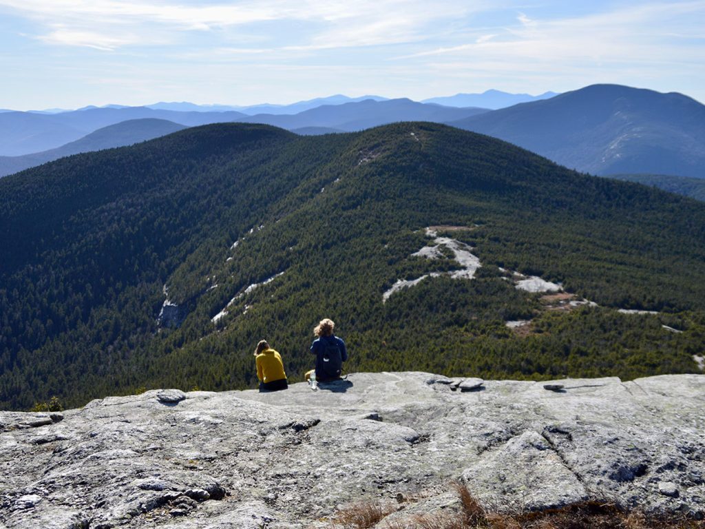 two people sitting on bald mountaintop