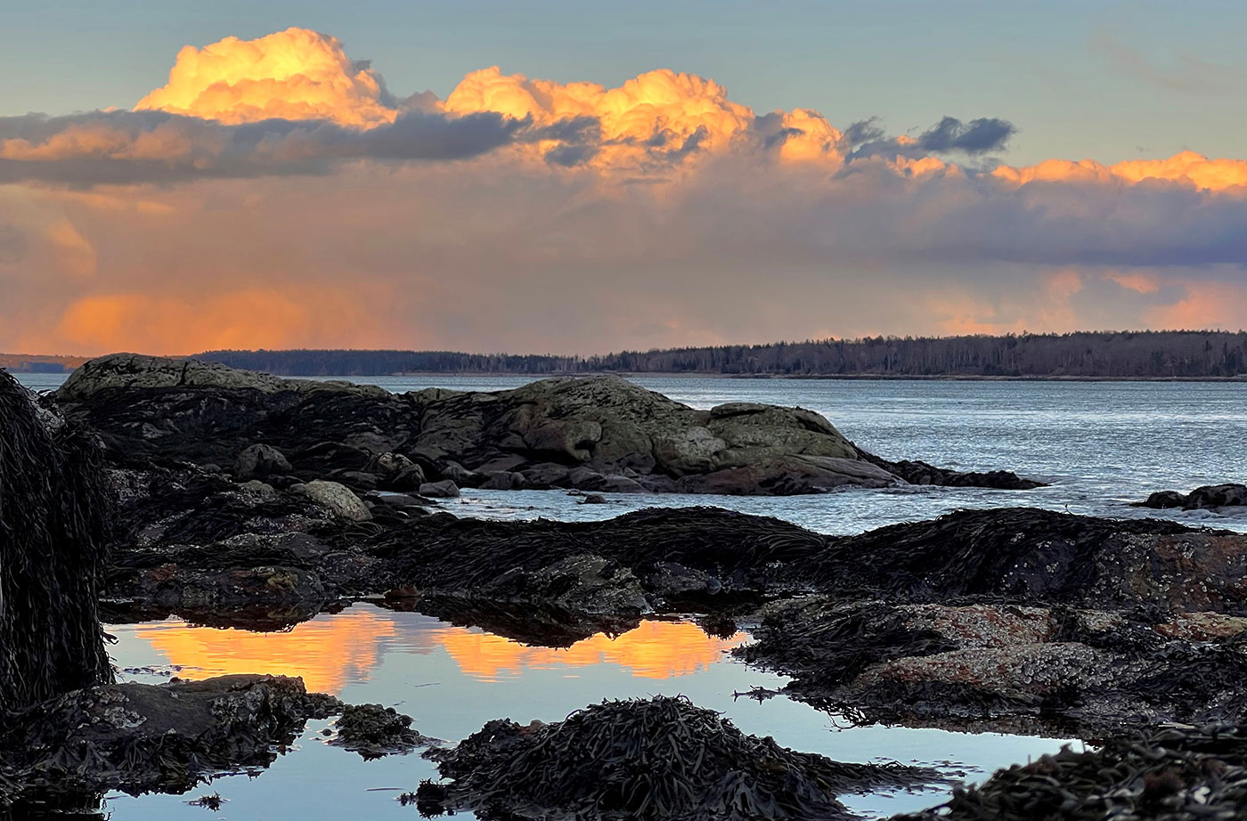 Snow squall and clouds over rocks in Muscongus Bay