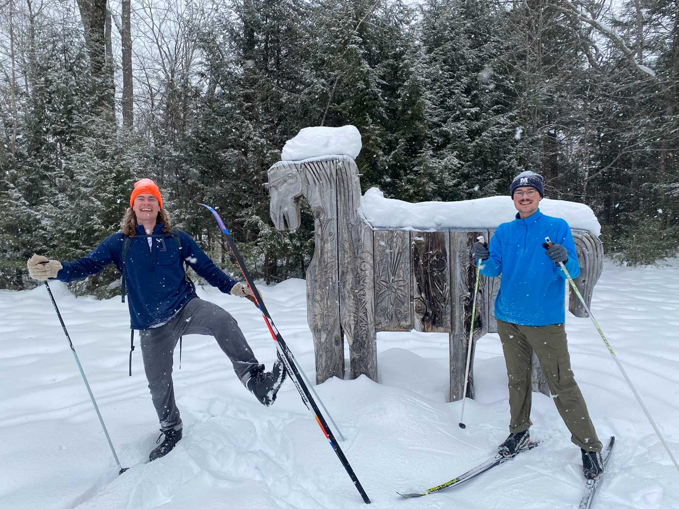 two people with skis smiling in the snow