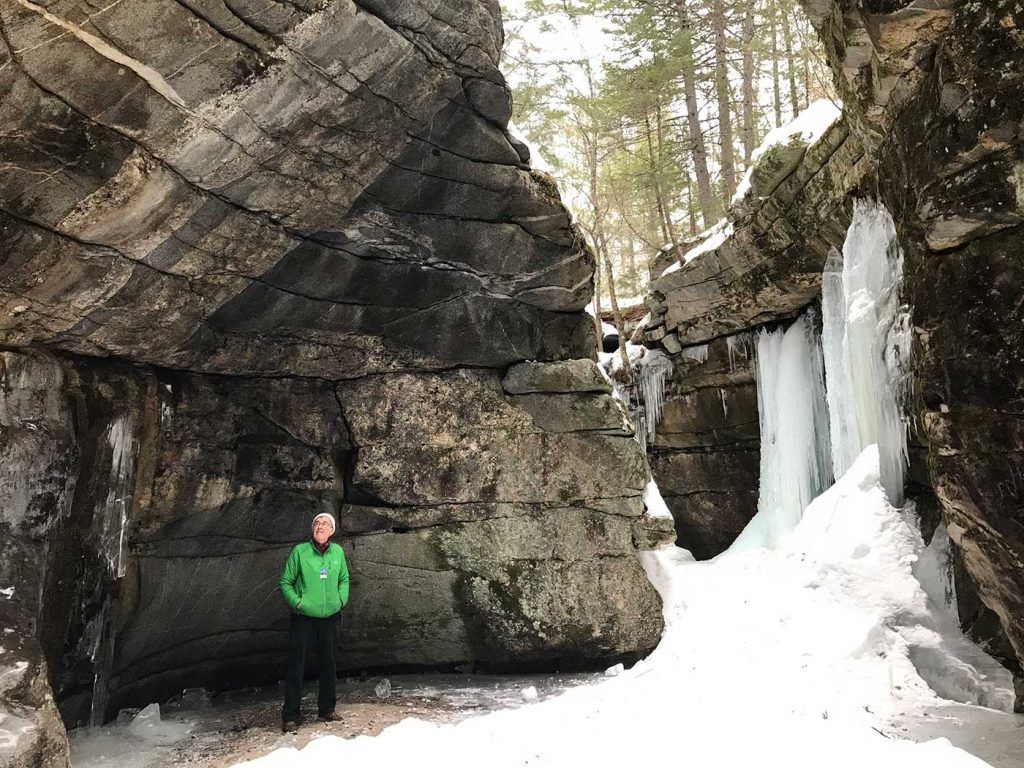 Man standing in front of rocks and ice