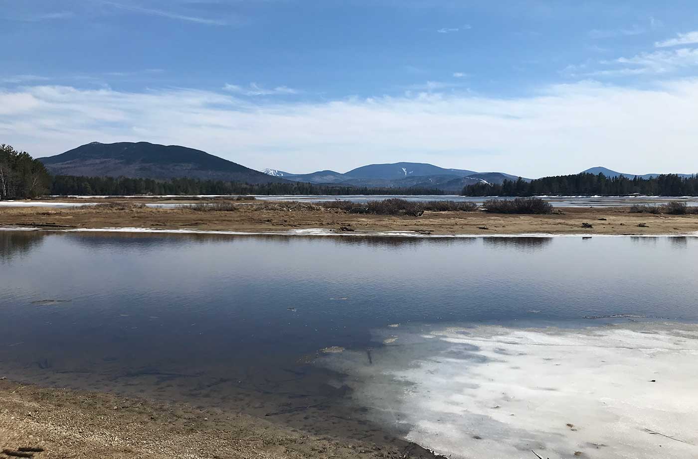 Flagstaff Lake with mountains behind and a little ice left near the shore