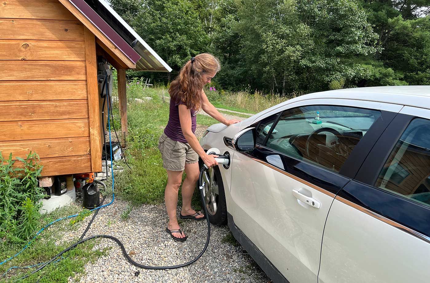 woman charging electric vehicle at home