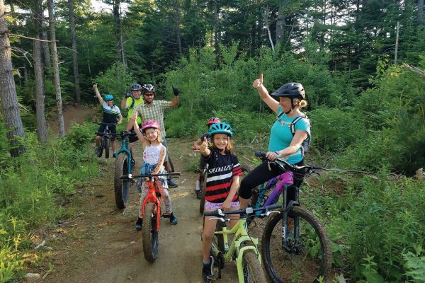 adults and children biking on trail
