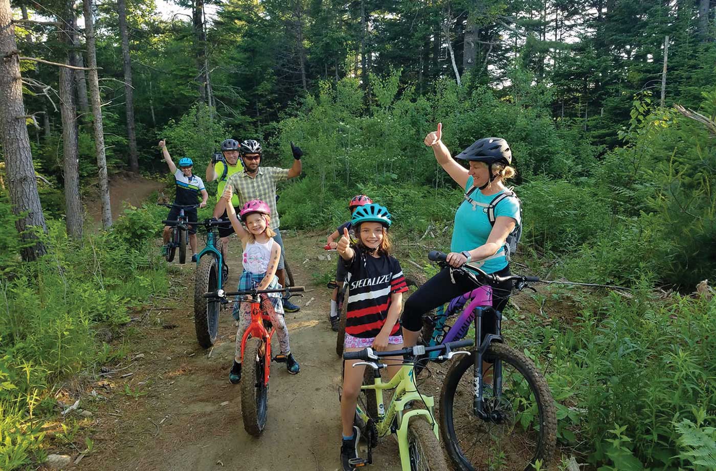 adults and children biking on trail