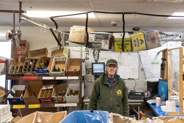 Portland Redemption Center employee standing in front of register.