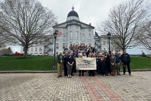 People on steps in front of Maine State House holding NRCM banner