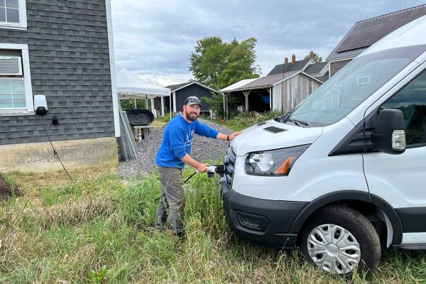 Man charging his electric van and smiling