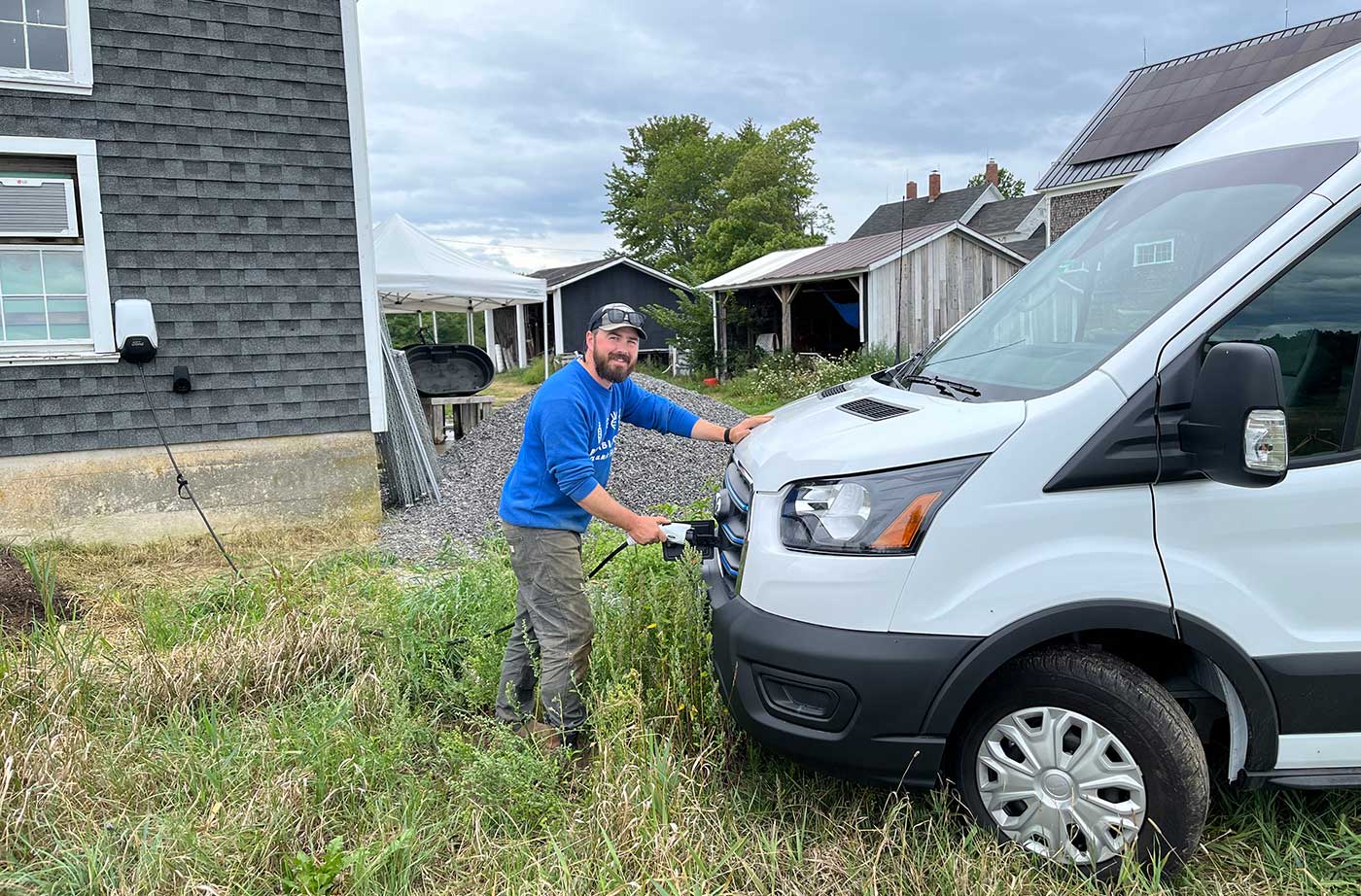 Man charging his electric van and smiling