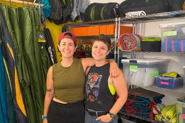 Two people standing in front of outdoor recreation equipment