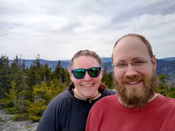 two people smiling with scenic vista behind them