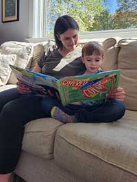 Mother and son reading book on sofa