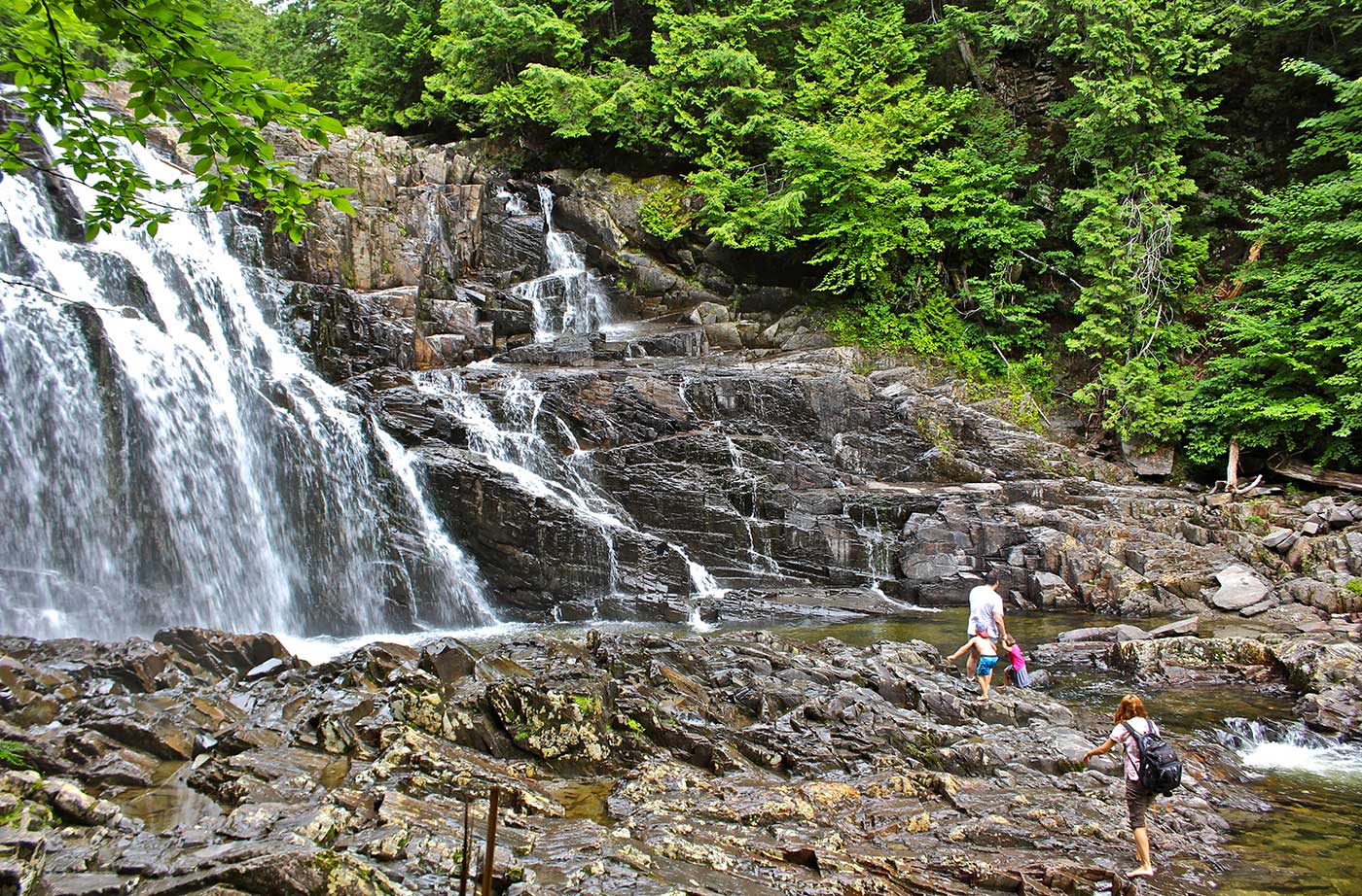 People walking toward waterfall