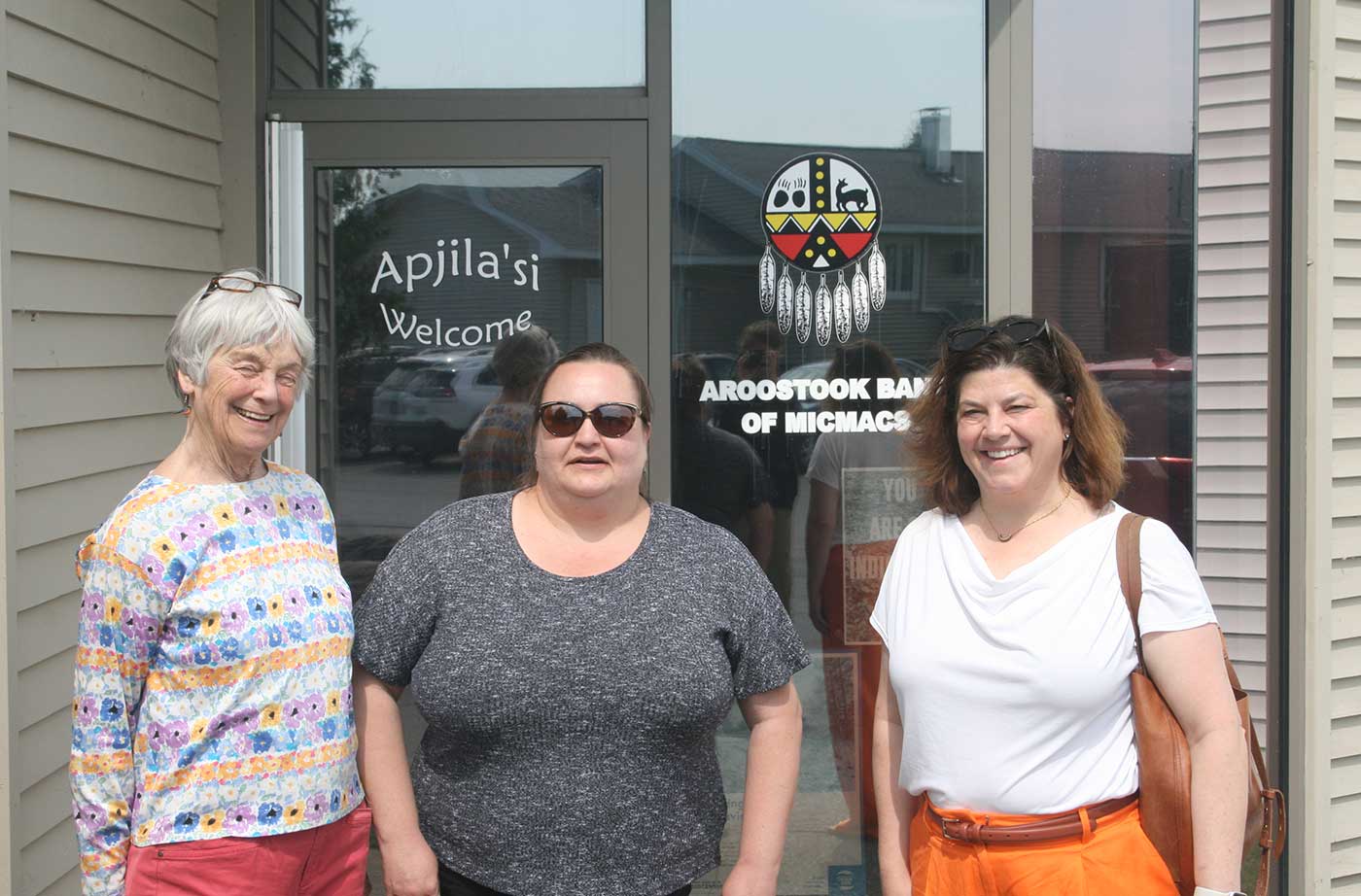Three women standing in front of Mi'kmaq Farms door