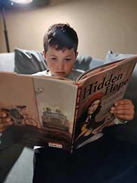 young boy reading book 