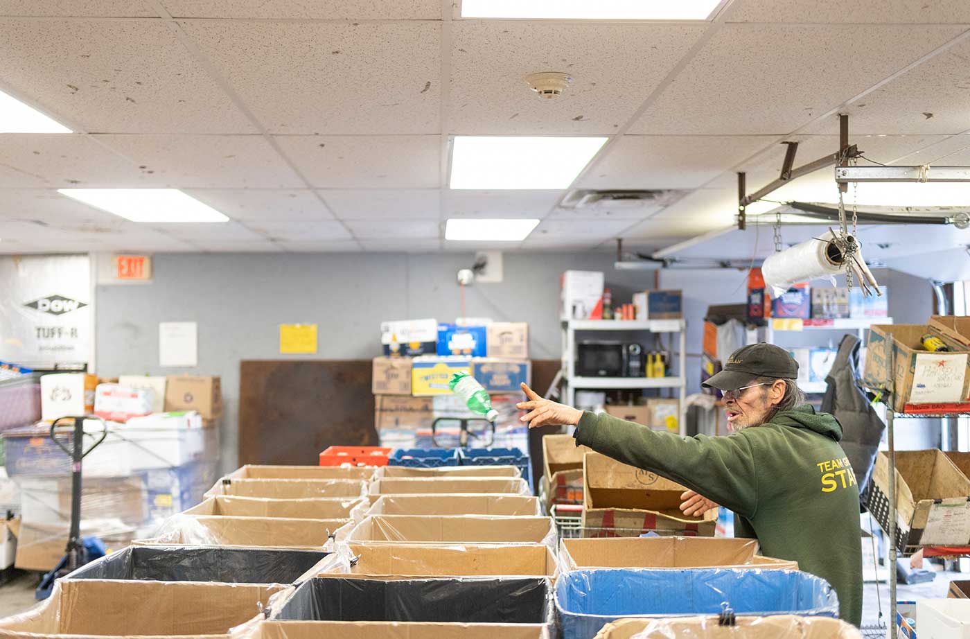 man throwing returnables into sorting cardboard containers