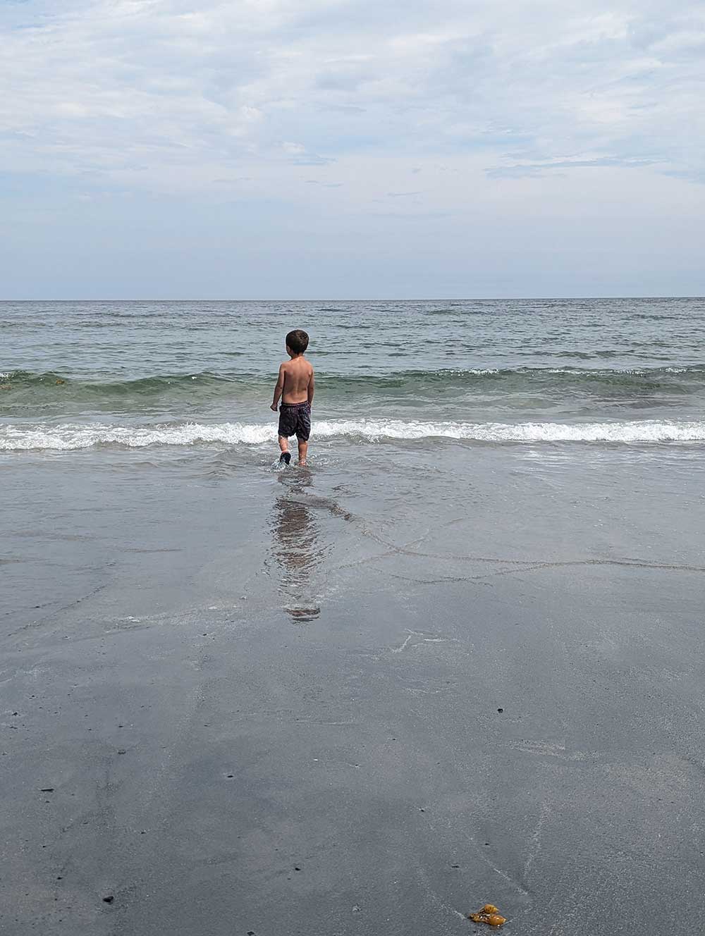 Young boy watching ocean waves