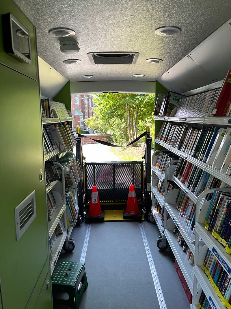 books on shelves lining inside of van