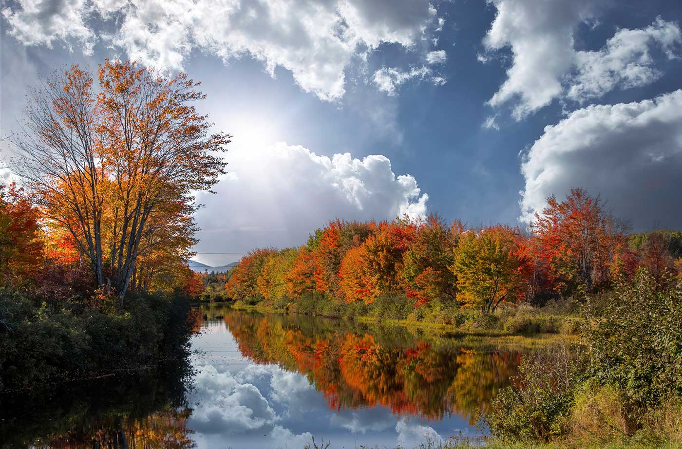 View of fall foliage and sunshine while looking down river