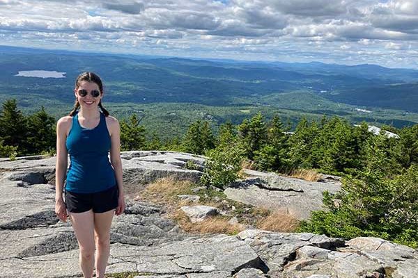 Kate Phillips standing atop mountain