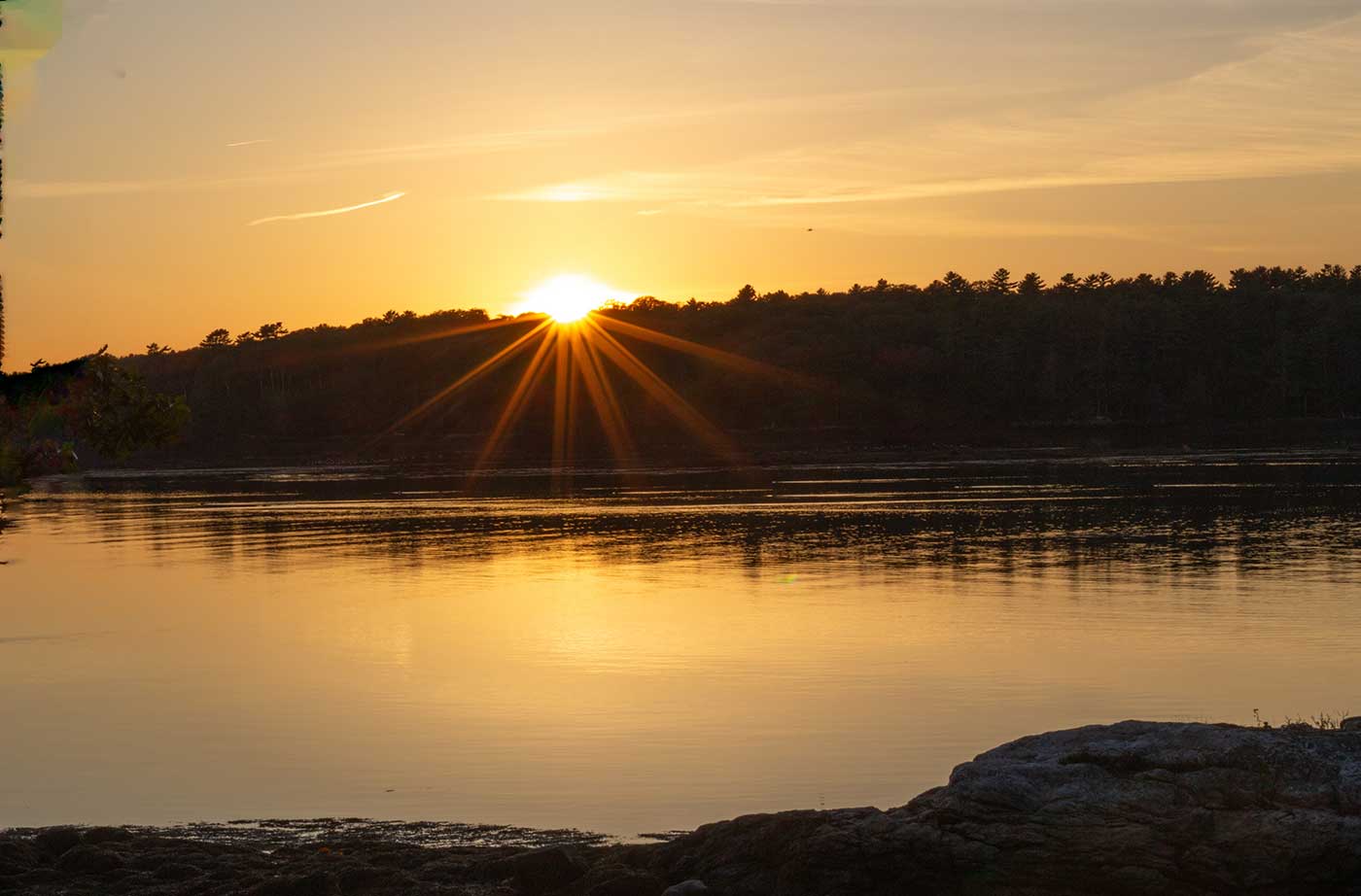 sunset over trees and water