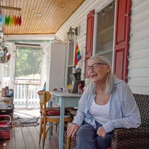 Woman sitting on her front porch, smiling