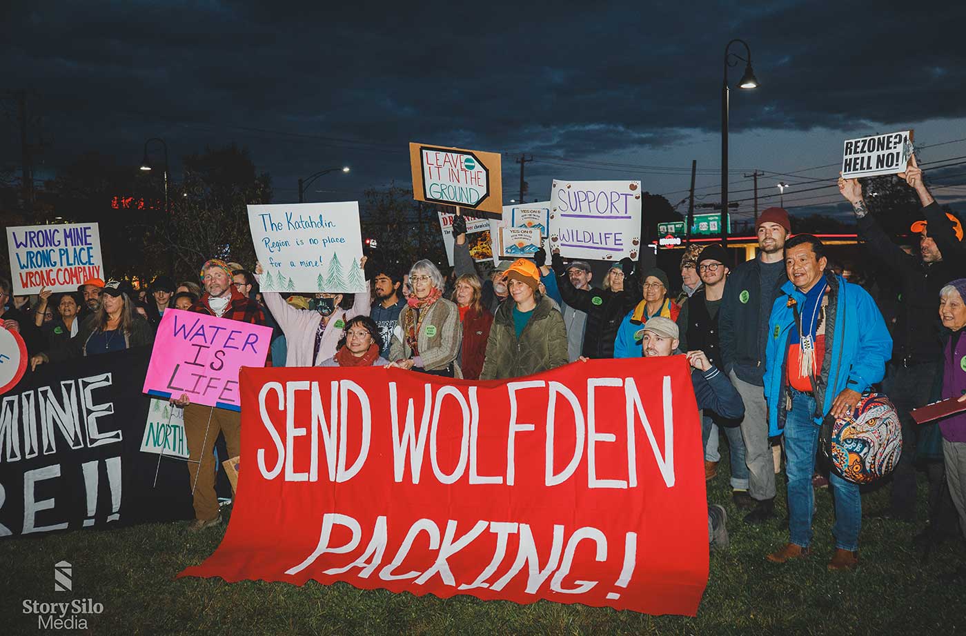 people holding signs opposing Wolfden mine