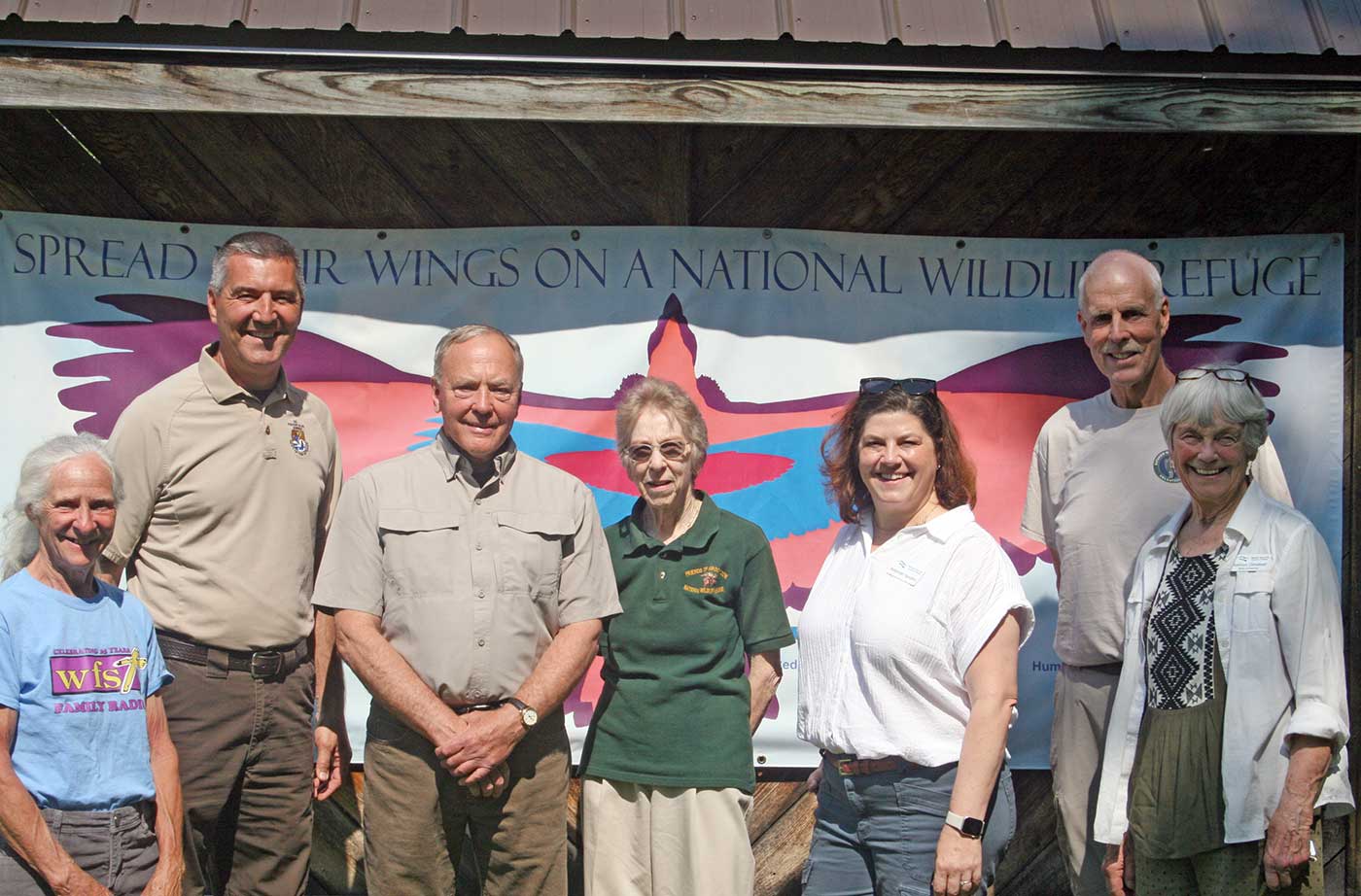 people standing in front of National Wildlife Refuge sign