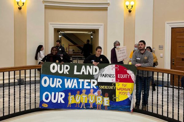 People standing with signs in State House hallway, in support of tribal sovereignty