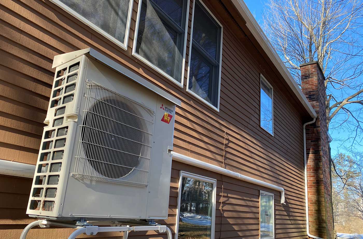 Heat pump condenser behind residential home