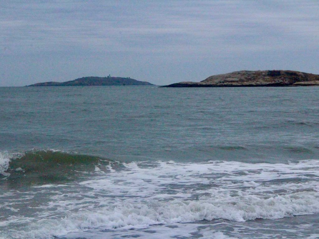 ocean waves with island behind them
