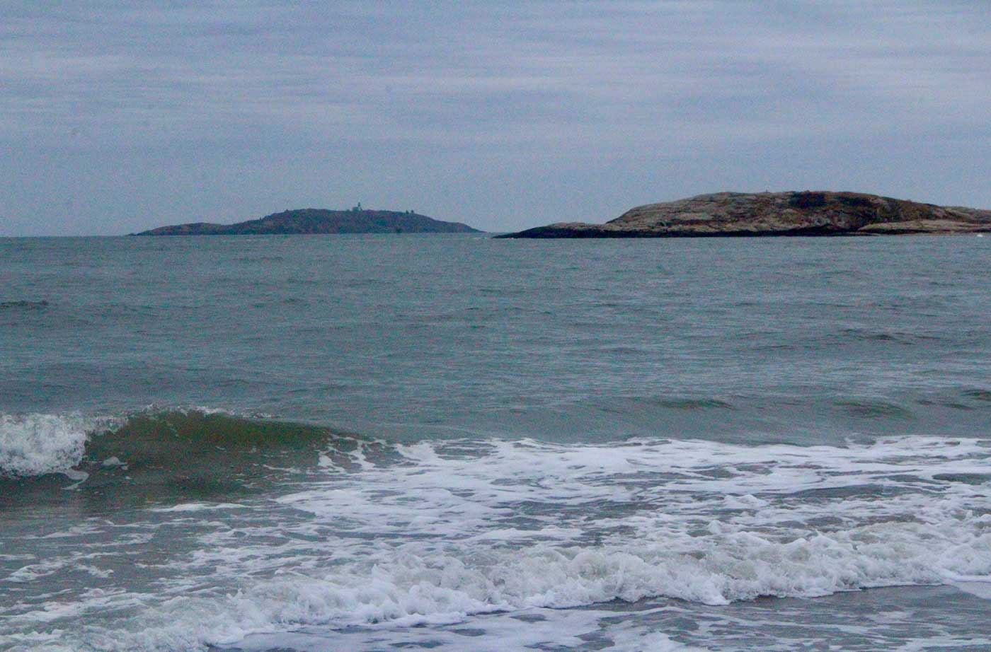 ocean waves with island behind them