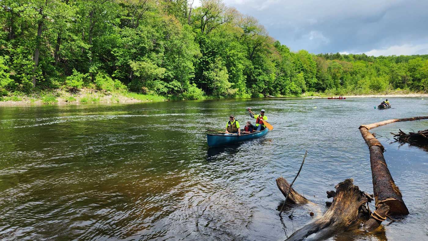 people paddling canoe in river